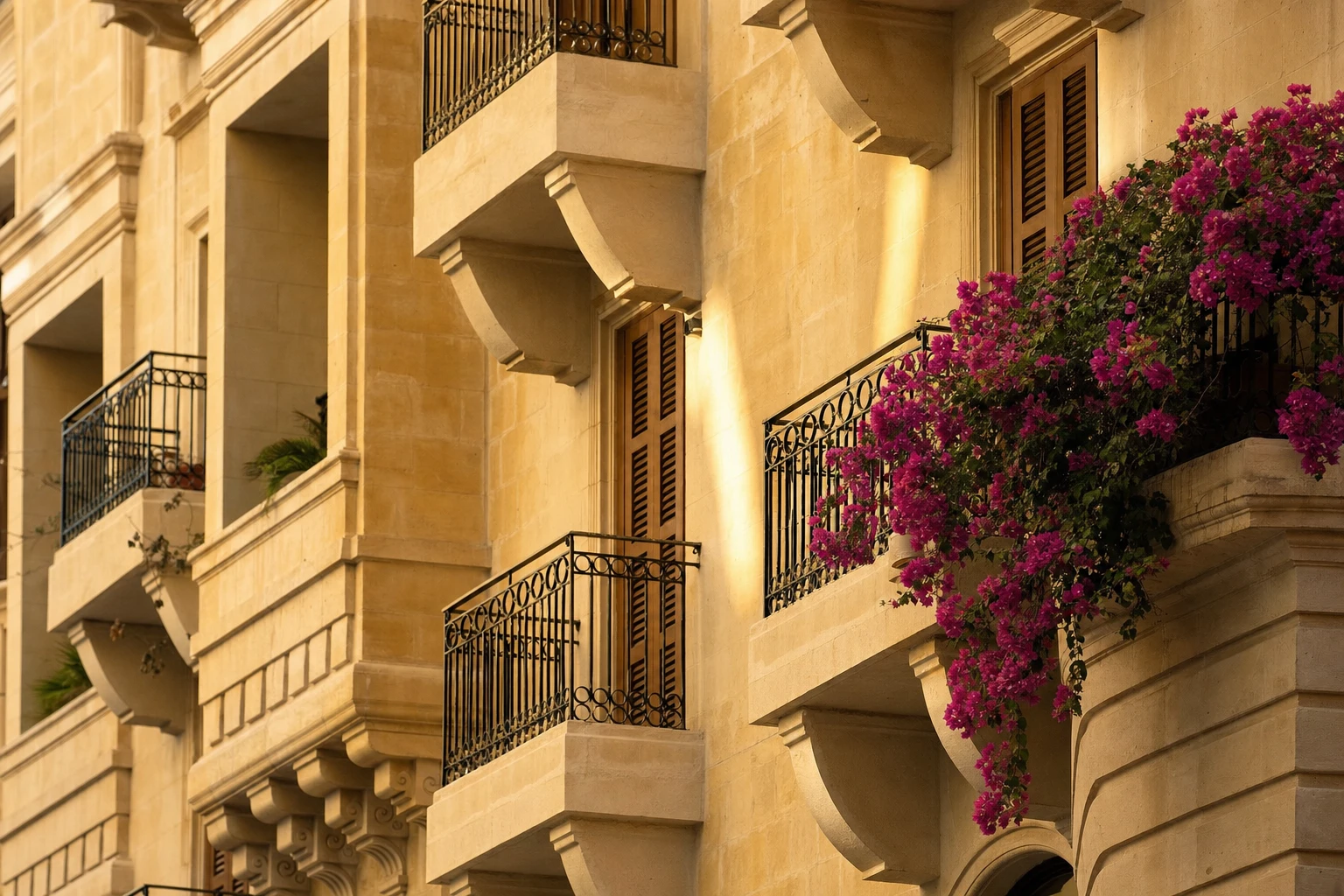 Close view of the limestone facade, balconies and shutters